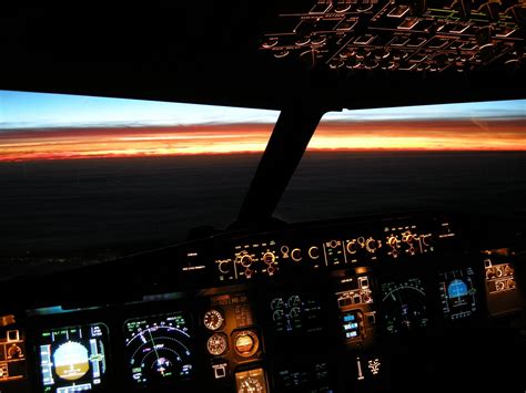 an airplane cockpit with the lights on at night and clouds in the sky ...