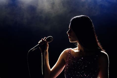 Premium Photo | Portrait of beautiful singing woman on dark background