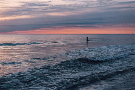Person Standing in the Sea during Sunset · Free Stock Photo