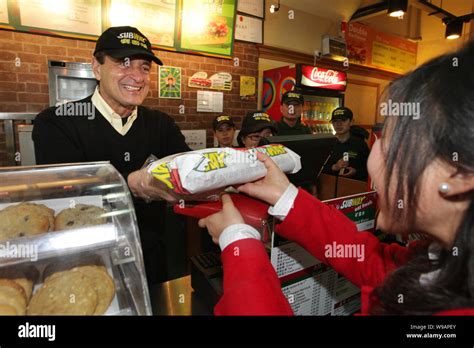 Fred DeLuca, President of Subway, serves a customer at a Subway restaurant in Shanghai, China ...