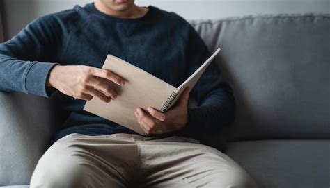 Premium Photo | Man reading the notebook sitting on the sofa at home