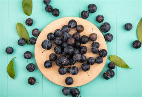 Free Photo | Top view of the small sour blackish fruit sloes on a wooden kitchen board on a blue ...
