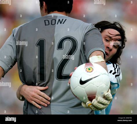 Brazil's goalkeeper Doni (L) catches the ball as Argentina's Lionel Messi challenges him in the ...