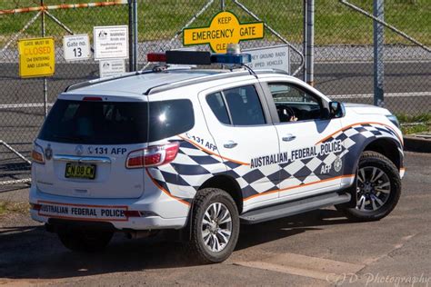 a white pick up truck parked in front of a chain link fenced parking lot