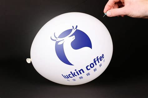 Hand uses a needle to burst a balloon with Luckin Coffee logo - Creative Commons Bilder