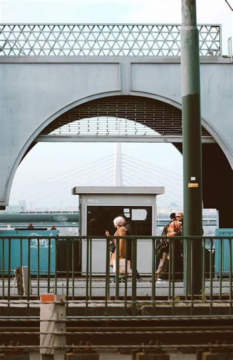 People Walking in City Near an Arch Bridge · Free Stock Photo