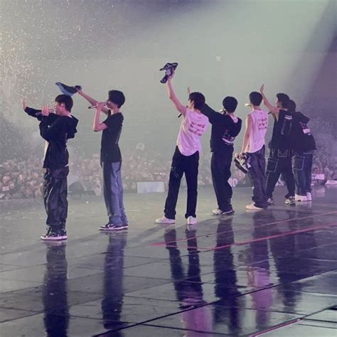 a group of young men standing on top of a stage with their arms in the air