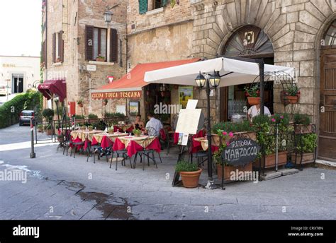 People sat at a table outside of Italian restaurant in Montepulciano ...