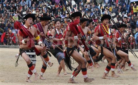 the men are dancing with spears in their hands