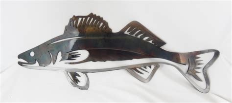 a metal fish sculpture sitting on top of a white sheet