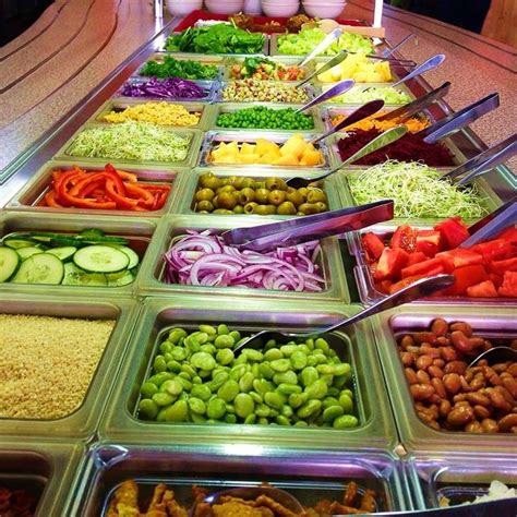 many trays filled with different types of food on display at a buffet ...