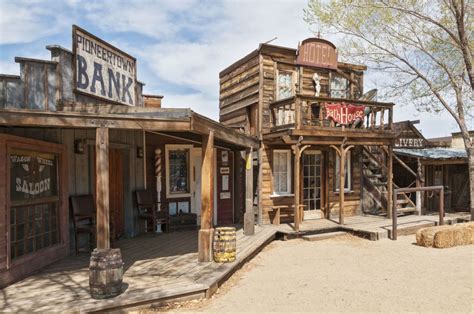 an old western town with wooden buildings and signs on the building's ...