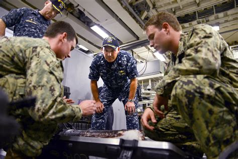 U.S. Navy Cmdr. Mark Haney, center, listens as U.S. Navy Petty Officers 2nd Class Daniel Clarke ...