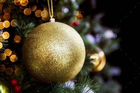 Christmas tree with golden ball and blurred lights. festive mood Stock Photo by mariiaplosh