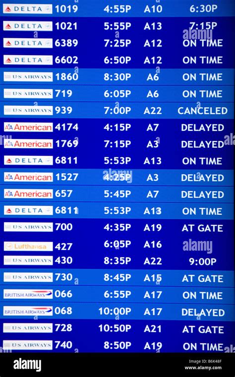 Airline flight schedule board at an airport showing delays and flight ...