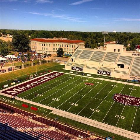 an aerial view of a football stadium with the sun shining on it's field