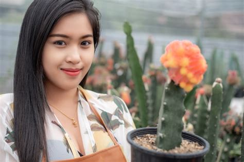 Premium Photo | Beautiful farmer checking quality of cactus plants with ...