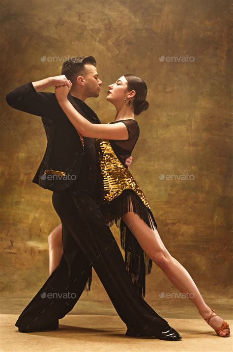 Dance ballroom couple in gold dress dancing on studio background. Stock Photo by master1305