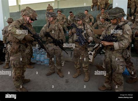 U.S. troops prepare their equipment before a squad live fire exercise ...