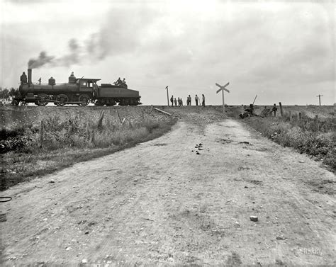 an old black and white photo of a train going down the tracks with people watching