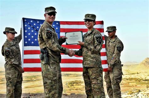 Sgt. Fatima Rivera shakes hands with Lt. Col. Frank Brewster during her reenlistment ceremony at ...