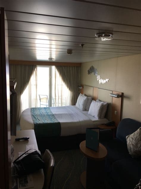 a bedroom with a bed, couch and television in it's corner area on a cruise ship