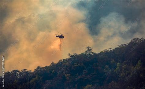 Fire fighting helicopter dropping water onto wildfire Stock Photo ...