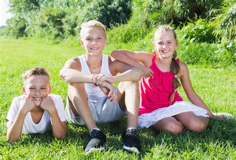 Happy kids laying on grass stock image. Image of enjoyment - 210662529