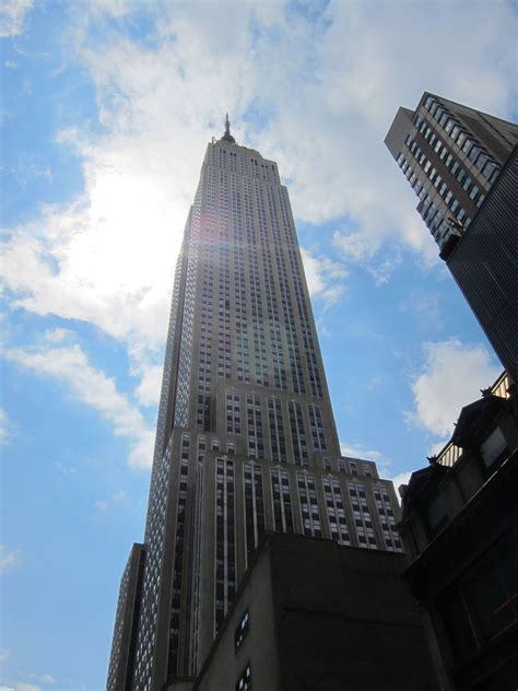 the sun shines brightly in front of tall buildings on a clear day with ...