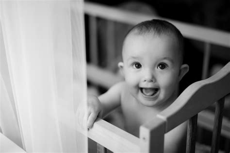 Premium Photo | Portrait of a 5monthold baby girl standing in a crib in a bright nursery after ...