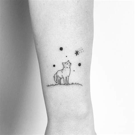 a small tattoo on the ankle of a person with a cat and stars in the sky