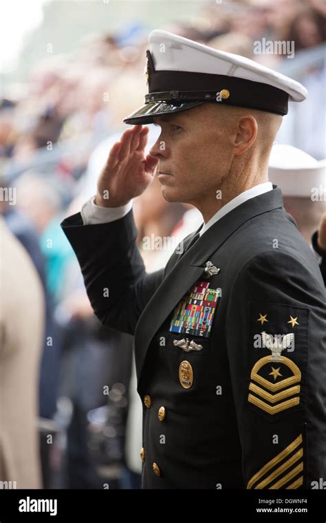 A U.S. Navy Master Chief Petty Officer salutes during the national ...