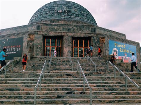 several people are walking up and down the steps to a building with a dome on top