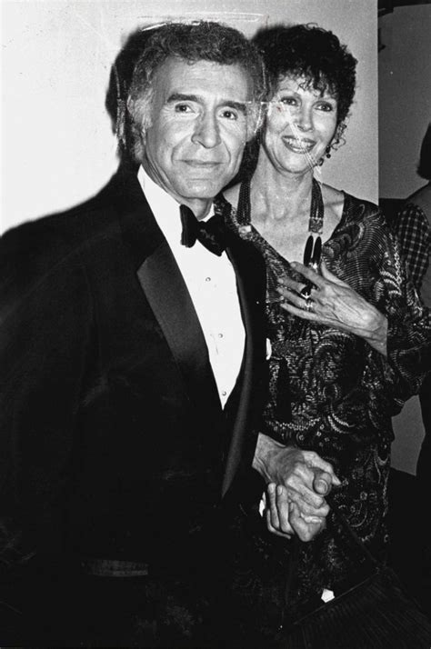 an old black and white photo of two people in tuxedos posing for the camera