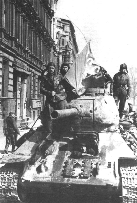 Soviet T-34 tank in the streets of Berlin after the end of the battle. Note the spare ...
