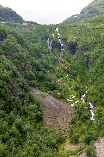 Premium Photo | A waterfall in norway a hiking trail winds sideways up ...