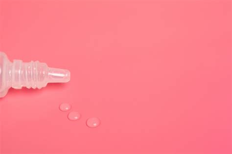 Premium Photo | Eye drops on pink surface