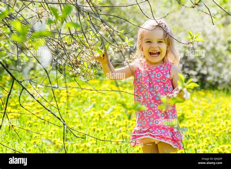 Happy little girl in spring sunny park Stock Photo - Alamy