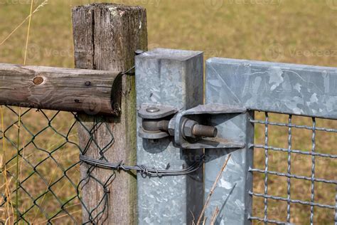 Metal hinge of gate on fence 9813259 Stock Photo at Vecteezy