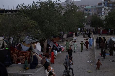 Photos show displaced families pouring into a makeshift refugee camp in Kabul as the fighting ...