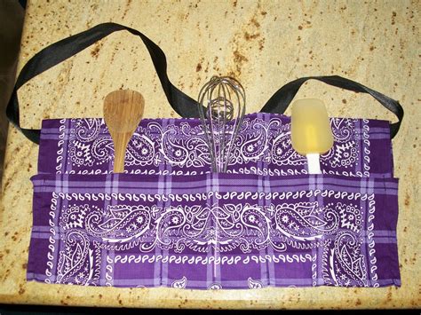 a purple bandana bag with wooden spoons and whisk set on it