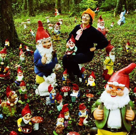 there are many gnomes in the woods and one is pointing at something with his finger