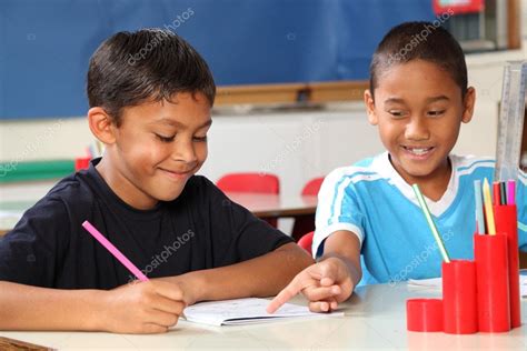 Two schoolboys helping each other learn in class during lessons Stock Photo by ©darrinahenry 5867074