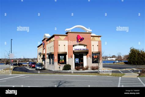 Taco Bell fast food restaurant exterior with drive-thru in New Bedford, MA USA with sunshine and ...