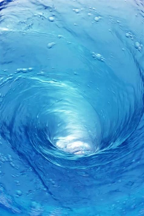 the inside of a blue ocean wave with water droplets