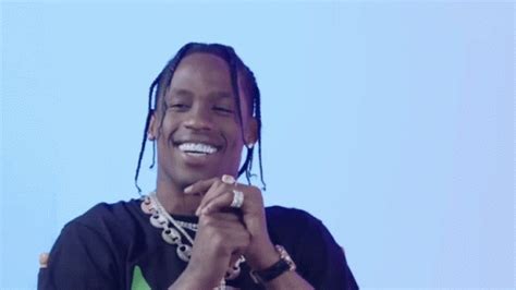 a man with dreadlocks smiles while holding his hands together in front of him