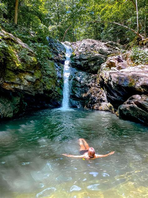 A woman swims in a pool at the base of a waterfall Shenandoah Valley, Shenandoah National Park ...