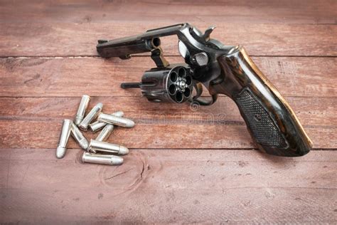 Black Revolver Gun with Bullets Isolated on Wooden Background Stock ...