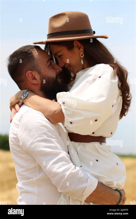 A photograph of a young couple hugging in the field Stock Photo - Alamy