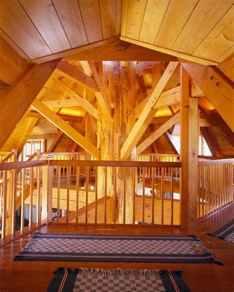 Unique second floor view of central, tree trunk post with radiating timberframe braces that ...